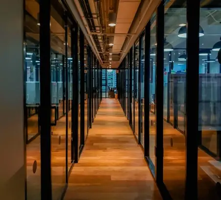 A corridor with glass-panelled offices on each side